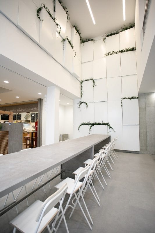 Restaurant- und Loungebereich mit modularer Wandverkleidung und stabilisierten Pflanzen – GREENIN