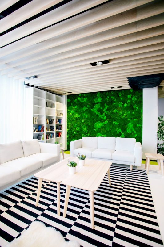 Mooswand hinter dem Lounge-Bereich mit weißen Sofas im IKEA Office